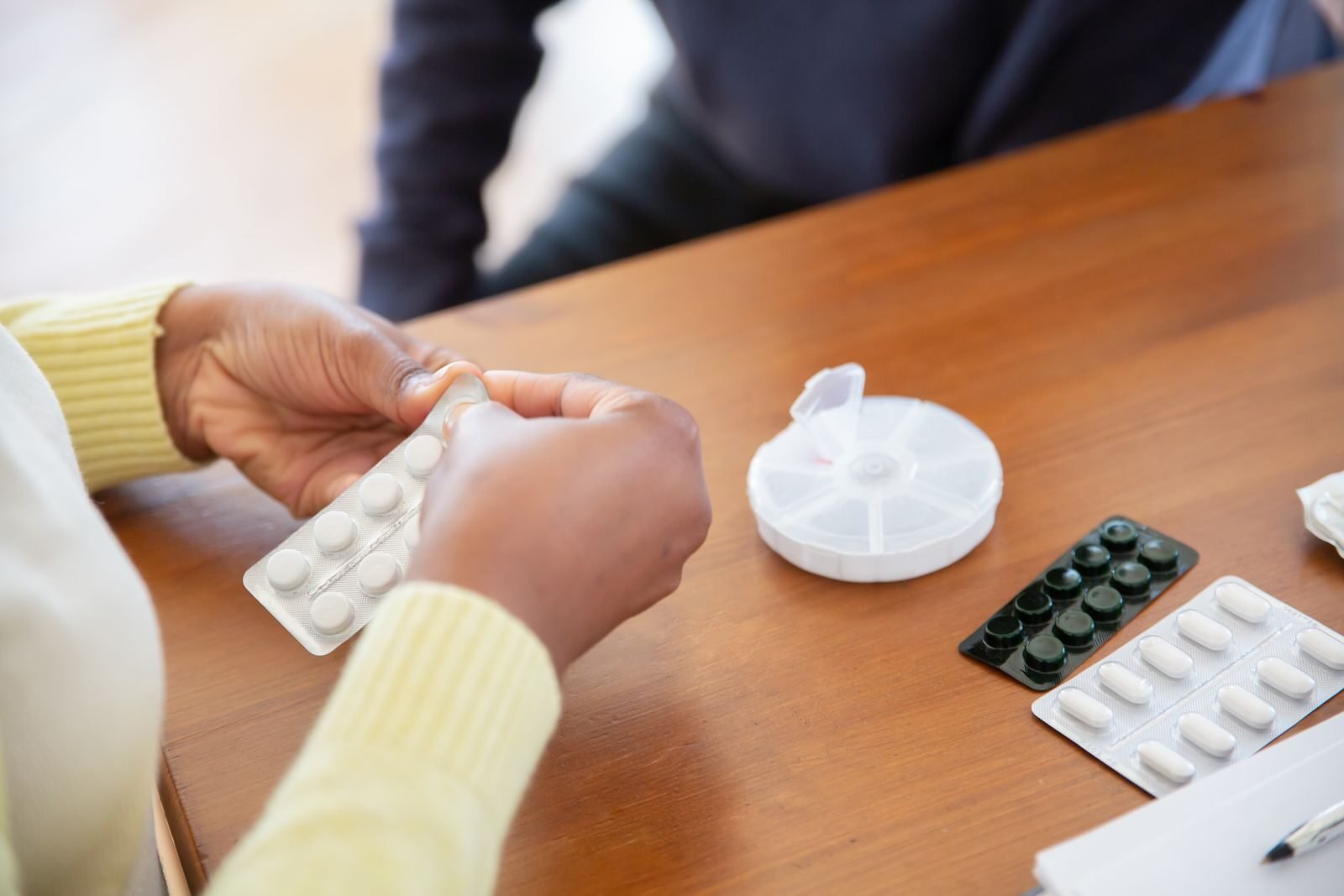 A Day in the Life of a Nursing Student: What to Expect at AA Nursing School Close-up of a nurse organizing pills and medications on a table in a care setting.